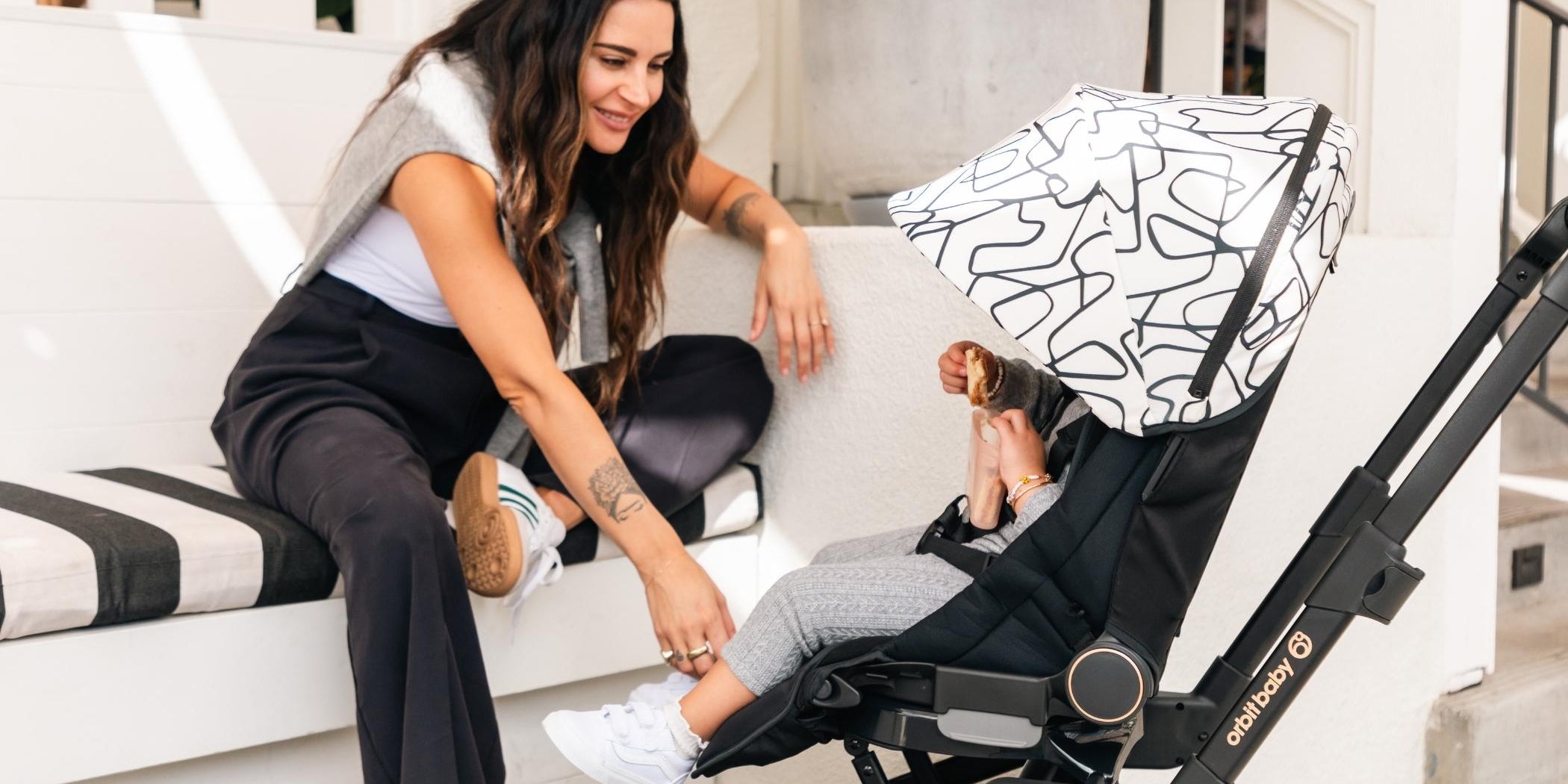 mom and baby with Orbit Baby foldable stroller for travel outdoors
