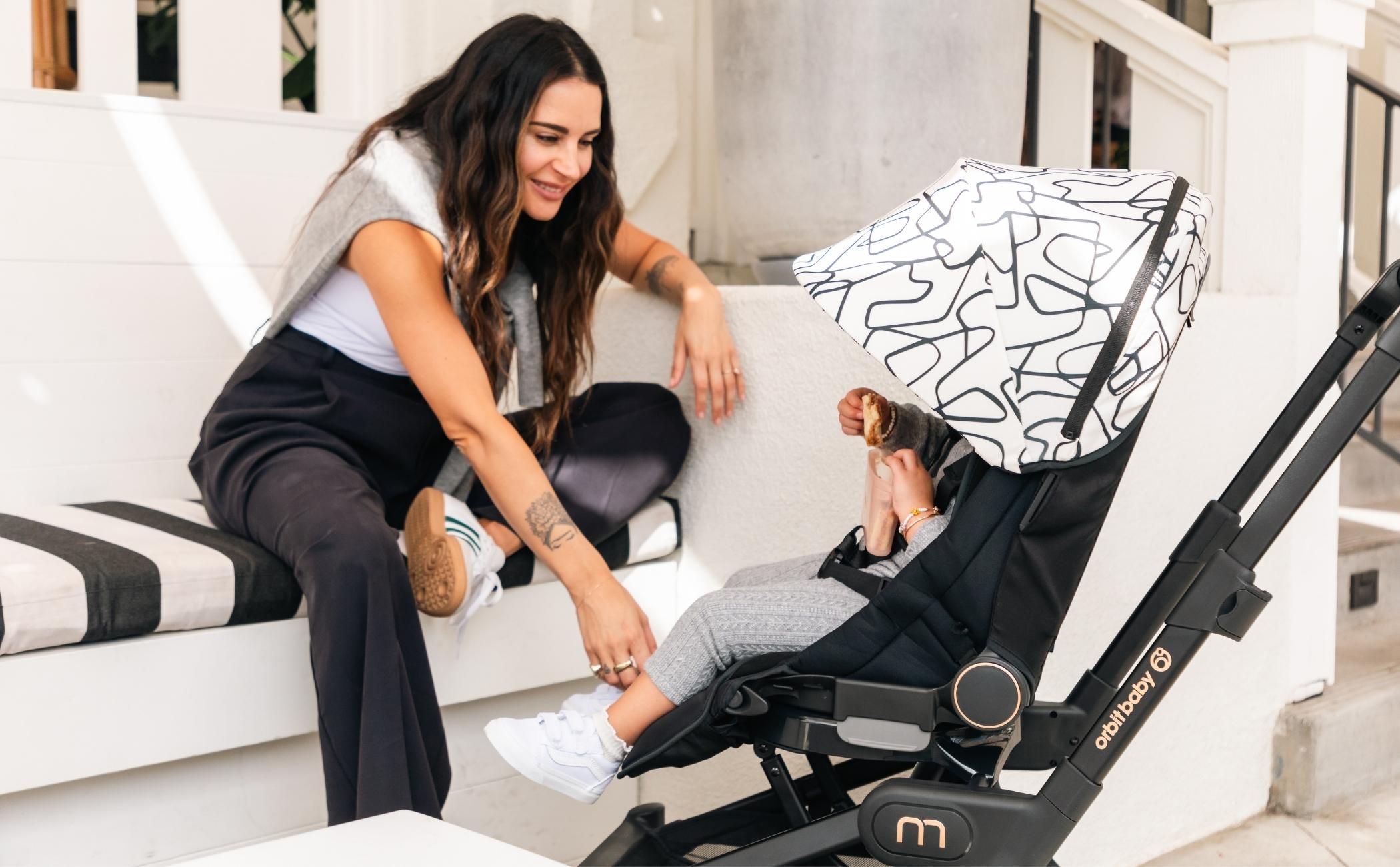 mom and baby with Orbit Baby foldable stroller for travel outdoors